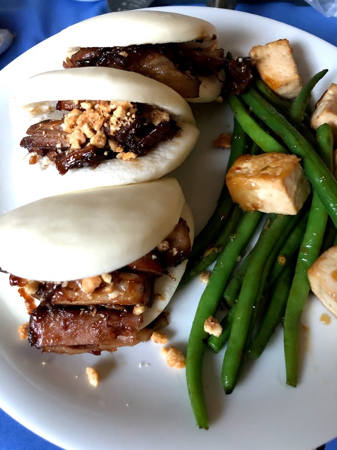 Bao buns with pork filling and crushed peanuts, with a side of spicy green beans with tofu