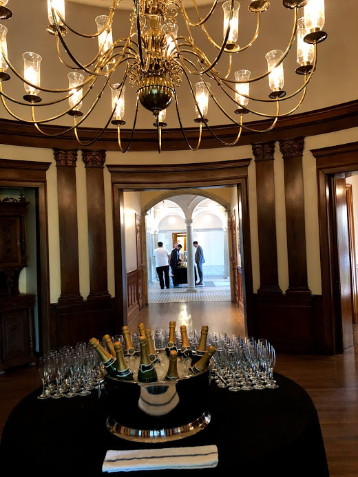 Picture of large champagne bucket with a dozen bottles chilling, surrounded by glasses, in a room at the Burrage Mansion in Redlands